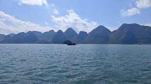 海上孤舟与远处山峦