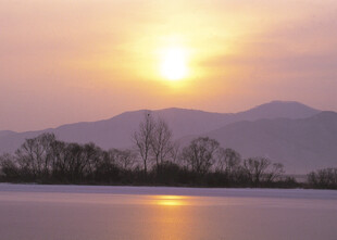 夕阳下的宁静湖面与远山