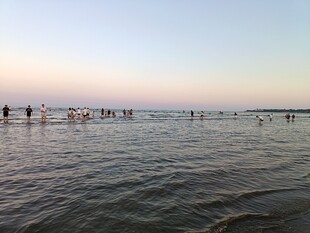 海边日落时的踏浪人群