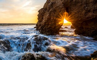 海边岩洞中透出的绝美落日