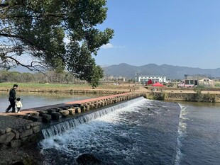 河边漫步的人及流水景观