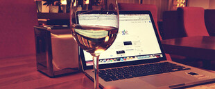 夜晚桌上的电脑与酒杯