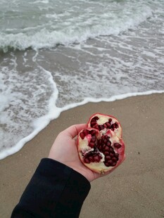海边手持红石榴的瞬间