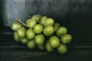 青葡萄串置于深色背景上
