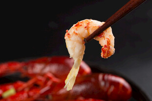 筷子夹起鲜嫩虾尾