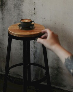 手触木凳上的咖啡杯
