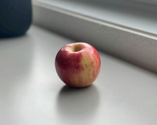 单个红苹果置于浅色平面