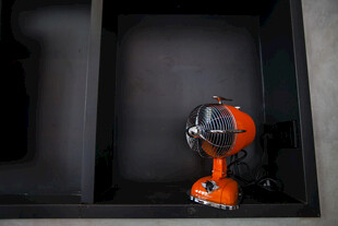 橙色电钻置于黑色置物架