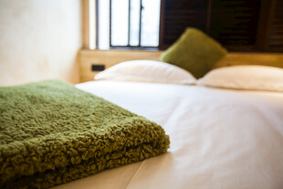 舒适卧室床铺与绿色毛毯