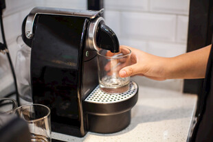 手捧杯接咖啡机流出咖啡