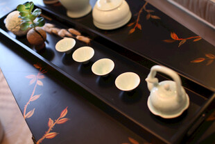 中式茶具摆设于古朴茶盘上