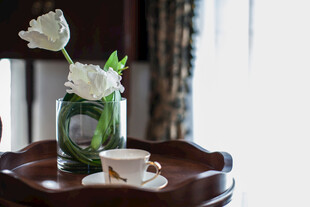 花瓶旁的咖啡与白玫瑰