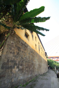 古老石墙旁的黄色建筑