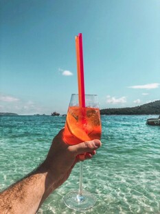 海边手持色彩缤纷鸡尾酒