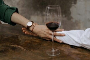 情侣桌前牵手共品红酒