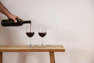 手倾红酒入高脚杯瞬间