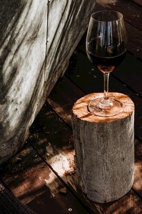 帐篷旁树桩上的一杯红酒
