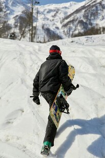 滑雪者雪地持板走向雪坡