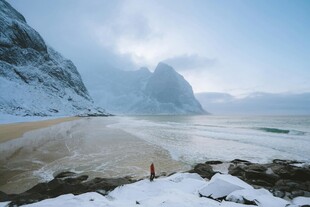 雪覆海滩与险峻山峰景观