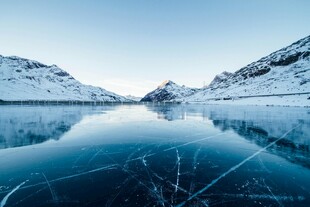 冰封湖面映雪山美景