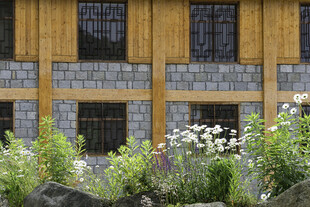 木质石砌房屋前的花草景