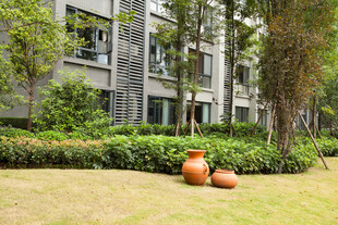 草坪陶瓮旁的绿植建筑景观