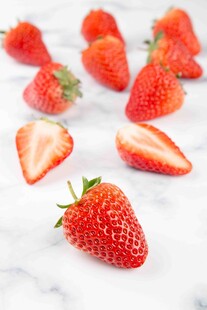 新鲜草莓散落在大理石台