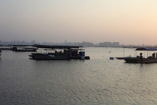 黄昏江畔停泊的几艘船只