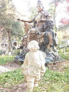 小孩凝视古代人物雕塑