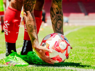 球员手持足球于绿茵场