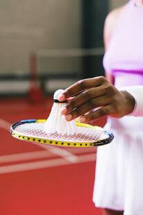 手握羽毛球拍的运动瞬间