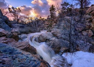 山间雪覆溪流日落美景