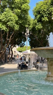 阳光下的喷泉与休憩人群