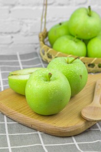 新鲜青苹果摆放在木盘上