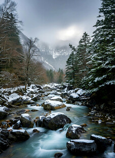 雪覆山林间的湍急溪流