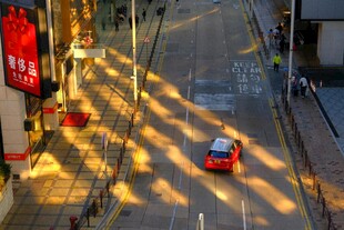 夕阳下街道上的红色小车