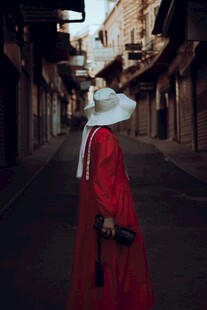 红衣人物于古朴街巷独行