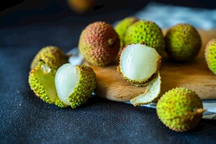 新鲜荔枝摆放在木砧板上