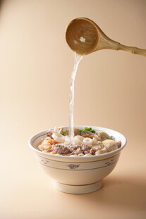 木勺浇汁于多彩食材碗中