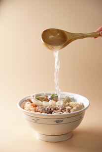 木勺舀汤入碗的温馨画面