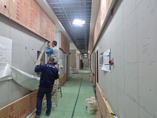 工人在狭长走廊进行装修工作