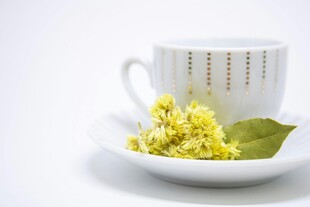 白杯旁的椴花与绿叶