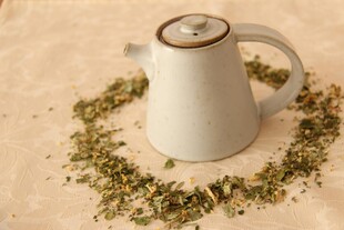 白色茶壶与散落的干茶叶