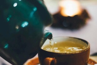 绿壶倒茶入杯的温馨瞬间