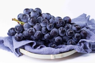 蓝布上的新鲜紫葡萄
