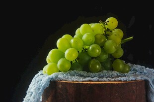 青葡萄置于布面木台上