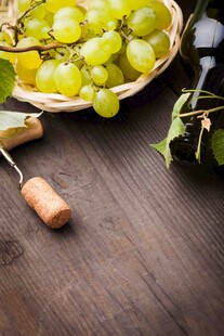 木桌上的青葡萄与开瓶器