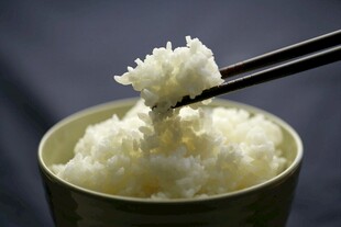 筷子夹起的一碗白米饭