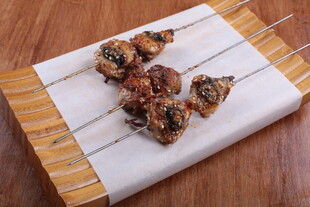 美味烤肉串置于竹制垫上