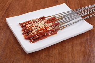 美味烤肉串放置于白盘上